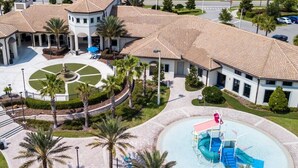 Un hotel amb un pati central, palmeres, una piscina i una font.