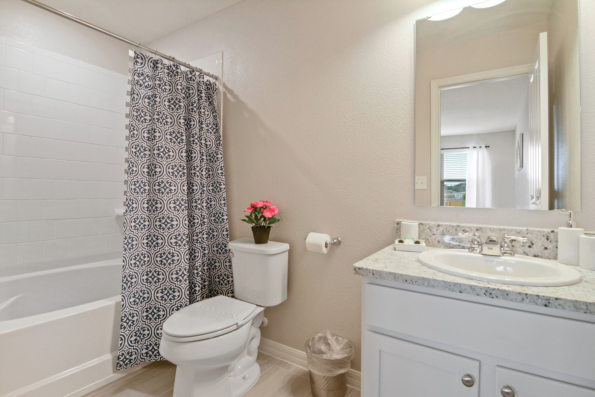 A bathroom with a toilet, sink, and shower curtain.