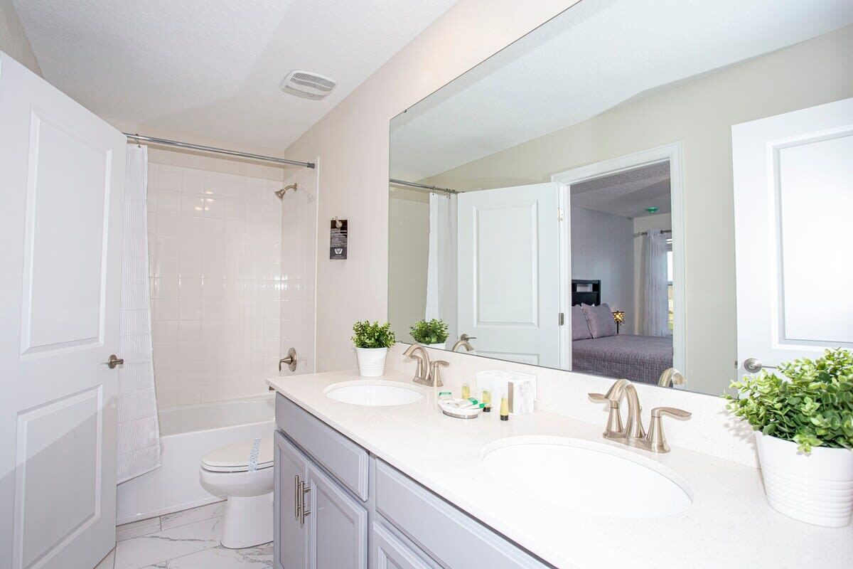 A modern bathroom with two sinks, a bathtub, and a shower.
