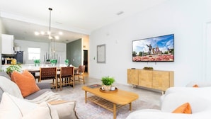 A modern living room with a sofa, coffee table, and dining area. - Gorgeous 2Bd Apto Close to Disney @ Storey Lake 404 3191 (Kissimmee)