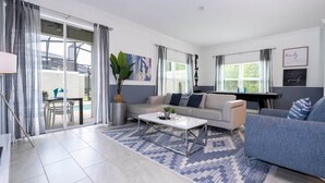 Un salon moderne comprenant un canapé, une table basse et un coin repas avec une table et des chaises.
