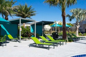 Relax in comfort under a shaded structure surrounded by lush greenery and palm trees.