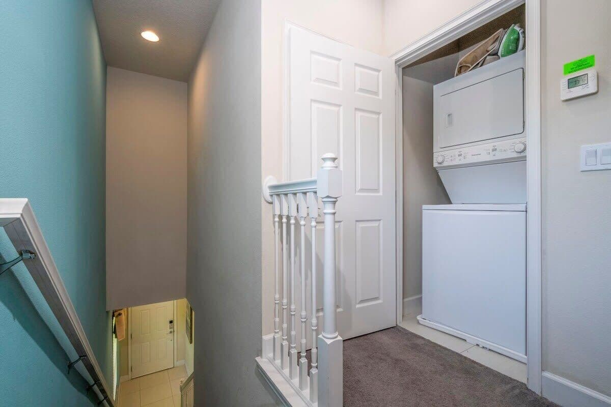 A laundry room with a white door, a washing machine, and a dryer.