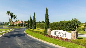 Tuscan Hills sign with a landscaped entrance featuring palm trees and a hedge. - Marvelous 4Bd Close to Disney w/ Pool at 313 Tuscan Hills (Davenport)