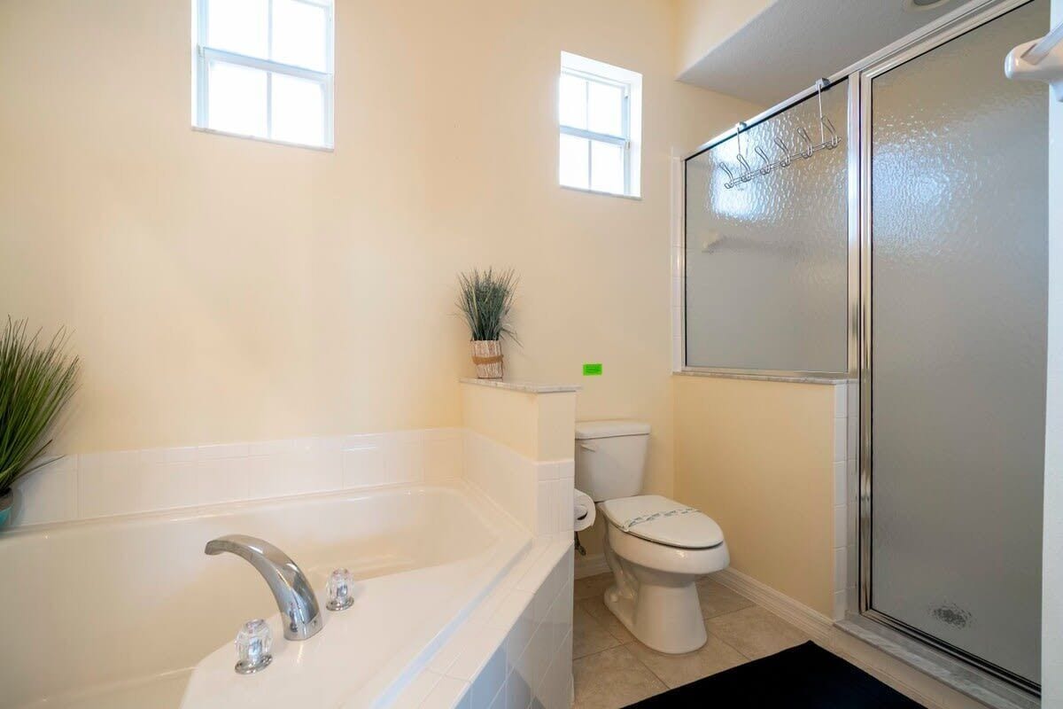 A bathroom with a bathtub, toilet, and shower.