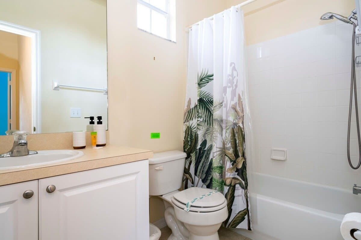 A bathroom with a toilet, sink, and shower.