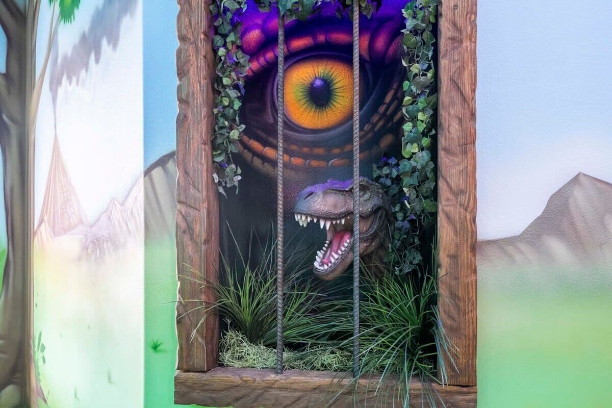 A dinosaur-themed display with a large eye and a roaring dinosaur head.