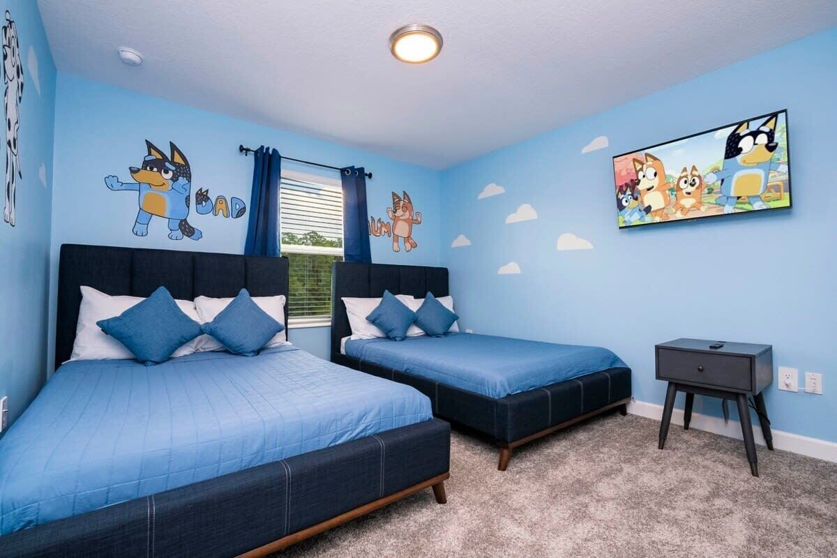 Ein Schlafzimmer mit zwei Betten, einem Fernseher und Wandbildern.