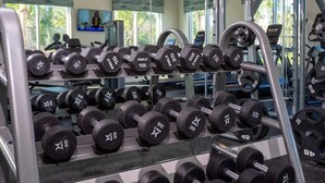 A gym with various weightlifting equipment, including dumbbells and weight plates. - Marvelous 4Bd with Pool at Storey Lake Resort 2601 (Kissimmee)