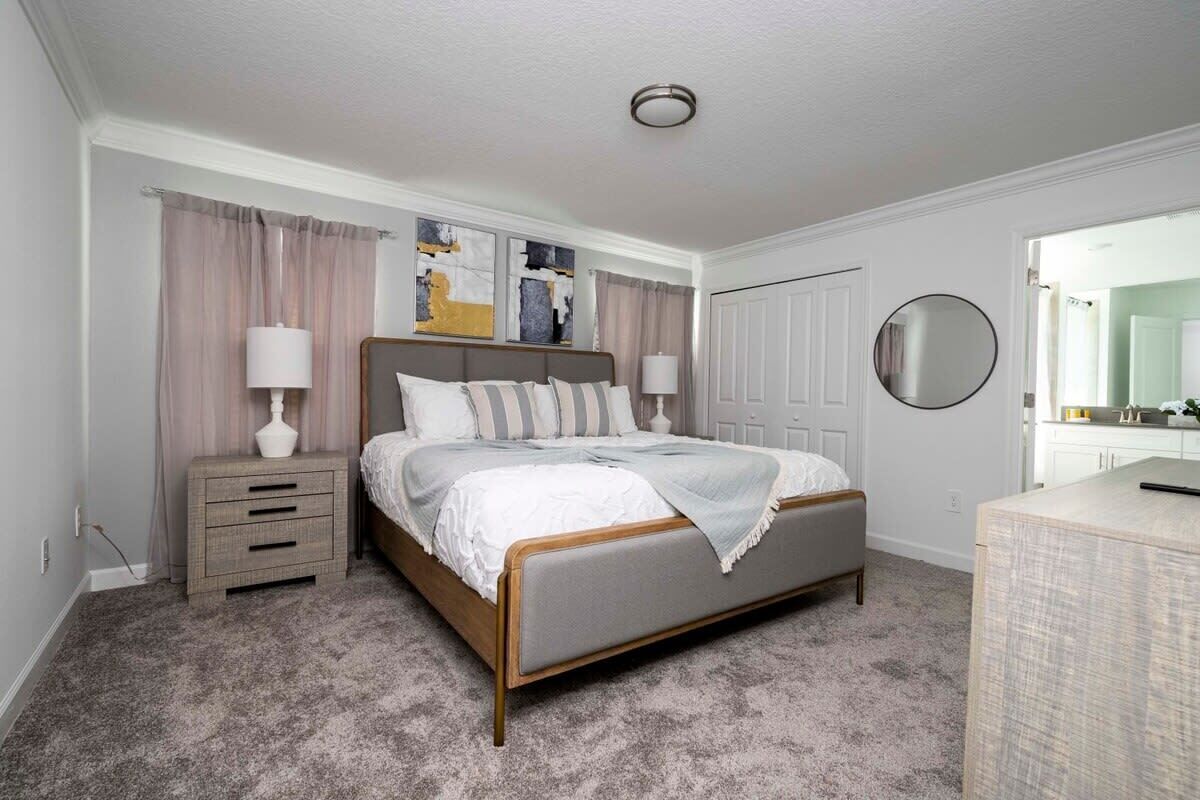 A bedroom with a bed, nightstand, and dresser.
