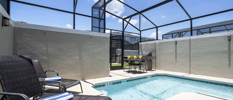 Una piscina al aire libre, sillones reclinables de piscina