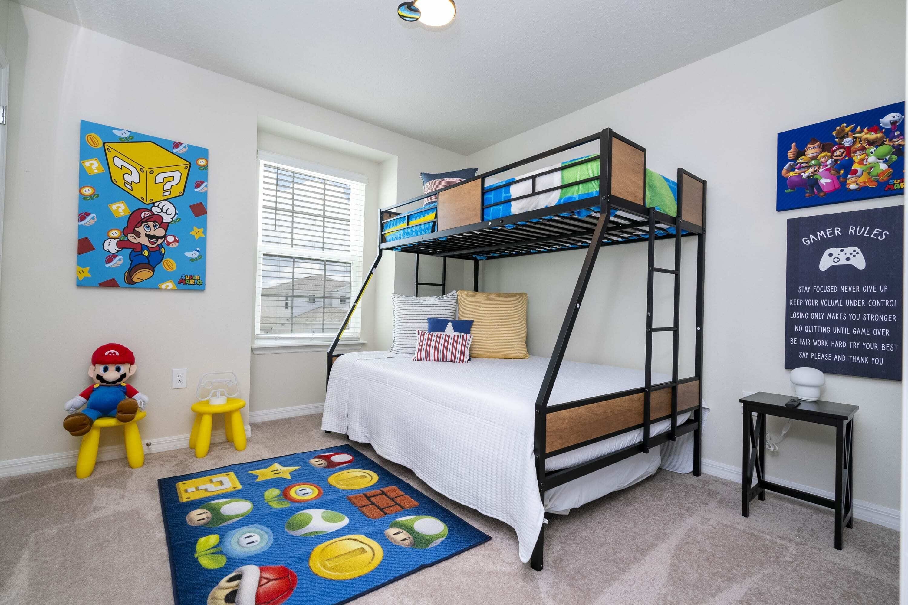 A bunk bed room with a Mario plush toy, a Mario-themed rug, and a poster with gaming rules.