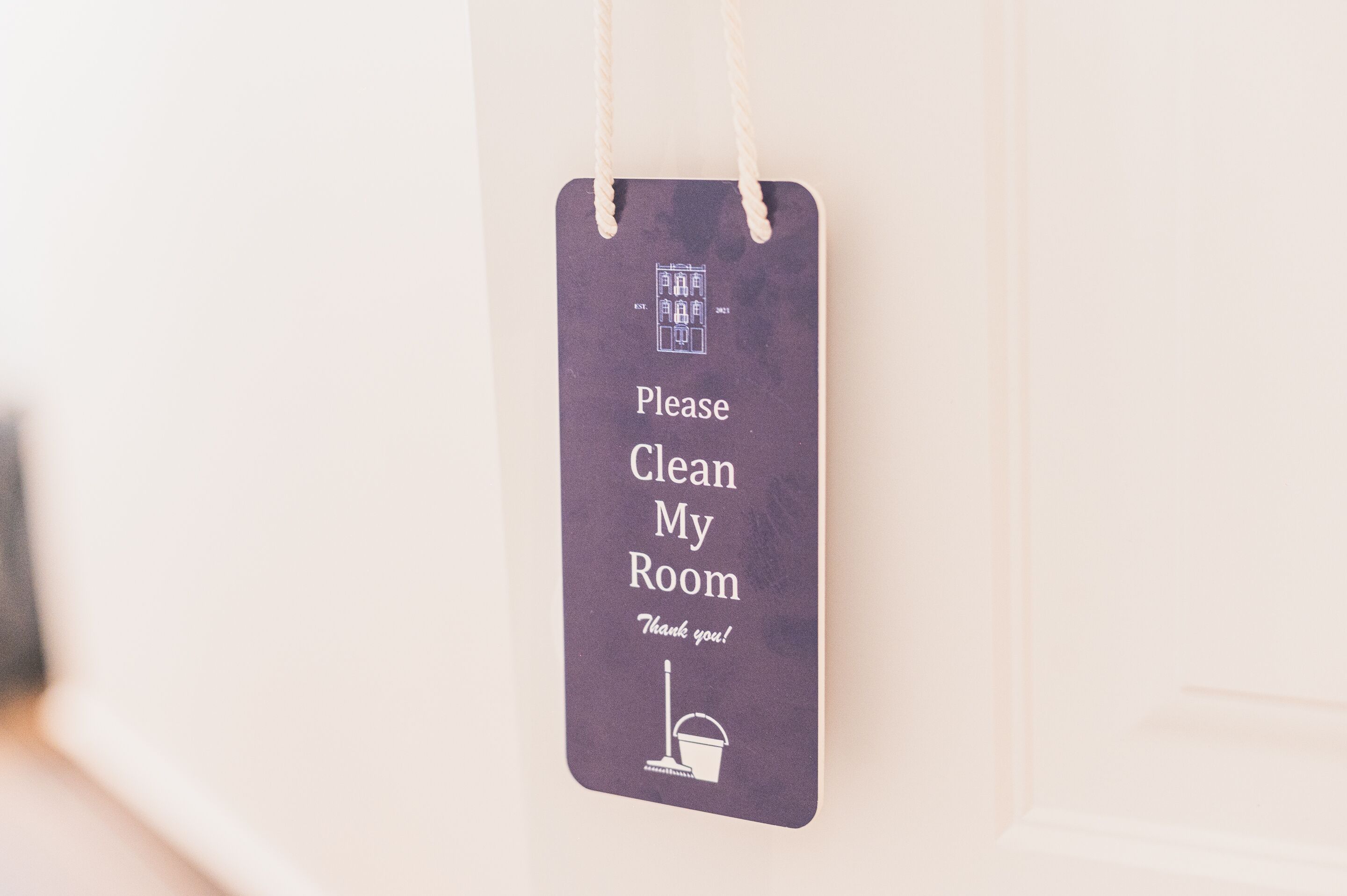 A sign with the text "Please Clean My Room Thank you!" and a broom icon.