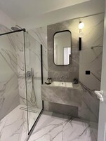 Shower, designer toiletries, hair dryer, slippers