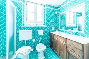 Un baño con inodoro, lavabo, espejo y bidé.