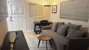 Un salon confortable avec un canapé, une table basse, une table à manger et une chaise.