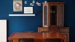 A dining area with a wooden table and chairs, a cabinet with glass doors, and framed artwork on the wall. - Apartment 5 minutes from Locarno Centro (Victoria Apartment) (Solduno)
