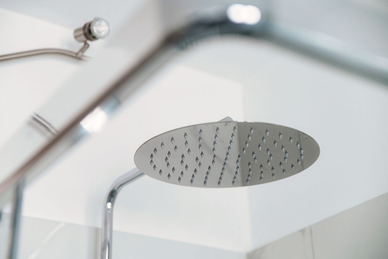 A modern showerhead with a curved design and a single handle.
