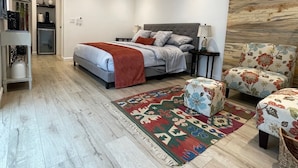 A modern bedroom with a bed, a ceiling fan, a wooden floor, and a decorative rug. - Wine Country Trail, View, Gated property, Detached Studio & Private View Patio, (Paso Robles)