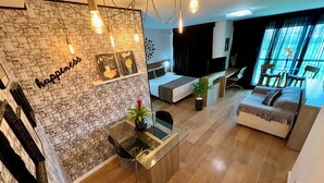 Ein modernes Wohnzimmer mit Steinwand, einem Glastisch, einer Couch und einem Fernseher.