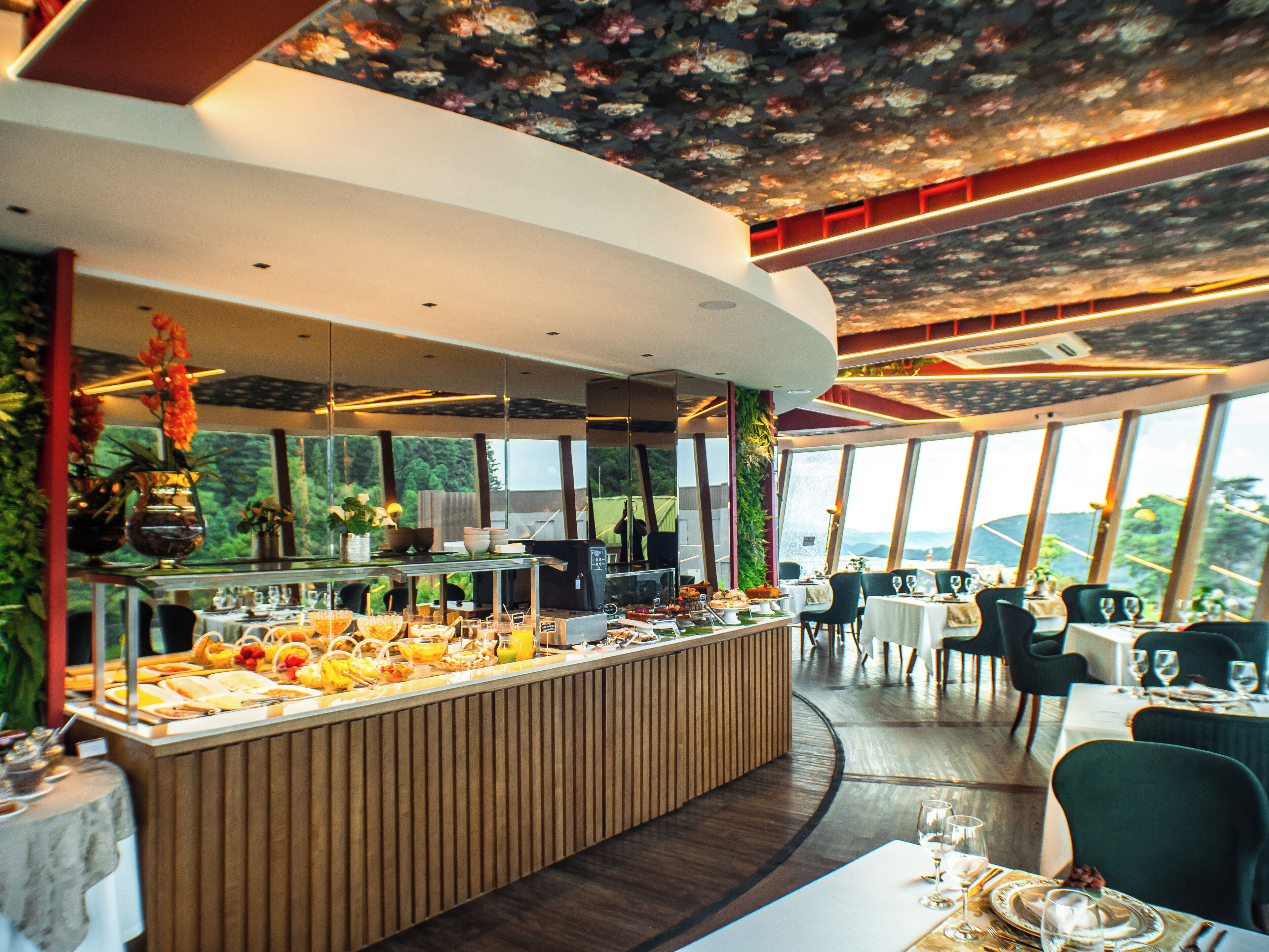 A restaurant with a buffet counter, dining tables, and chairs.