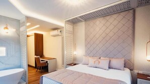 A modern hotel room with a large bed, a desk, and a separate bathroom area. - Hotel RF Vision (Gramado)