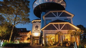 A hotel with a modern design, featuring a prominent circular structure on the roof and a sign that reads "RF Vision Hotel & Restaurant". - Hotel RF Vision (Gramado)