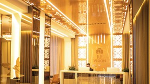 A modern hotel lobby with a reception desk, seating area, and decorative lighting. - Hotel RF Vision (Gramado)