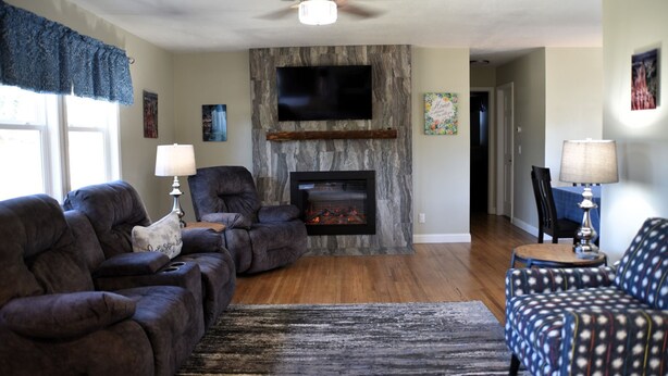 A living room with a fireplace, two sofas, a television, and a patterned rug. - At Home on South Canyon 
Newly remodeled Ranch home with plenty of space. (Rapid City)