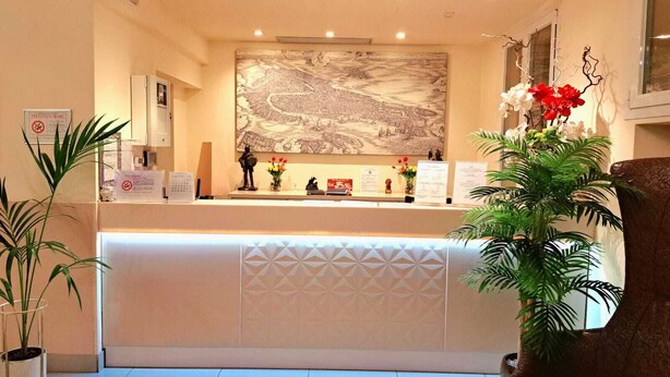 A reception area with a map on the wall, a reception desk, and potted plants. - Hotel Laguna Residence (Mestre)