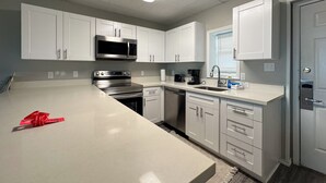 Una cocina moderna con armarios blancos, electrodomésticos de acero inoxidable y una isla grande.