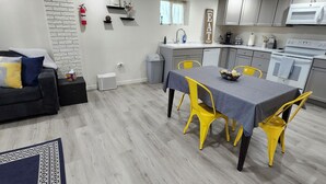 A compact living space with a dining area, kitchenette, and a small seating area with a couch. - Spacious & Modern Guest Apartment with Private Entrance (Smithfield)