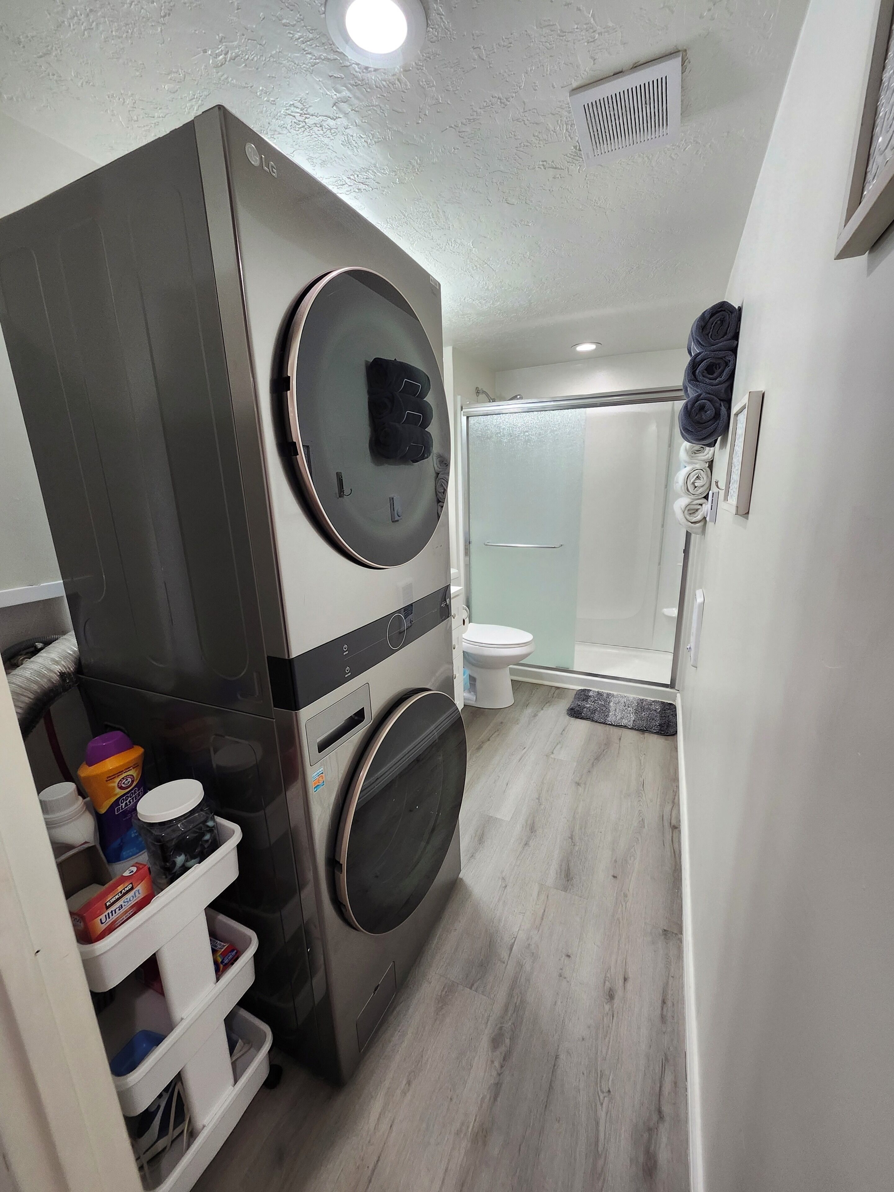 Casa de banho compacta com máquina de lavar, sanita e zona de duche.