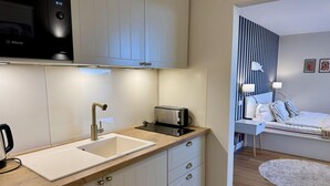 A modern kitchen with a sink, toaster, and Bosch appliance. - Salzwasser - Modernes App. mit Balkon, Meerblick, Pkw-stellplatz, Wlan. Haustiere Erlaubt (List)