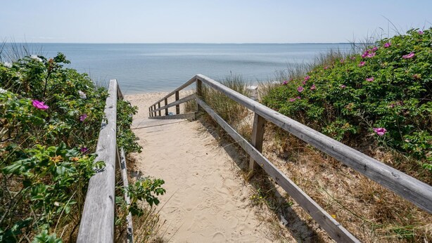 A wooden staircase leading to a sandy beach with a view of the sea. - Salzwasser - Modernes App. mit Balkon, Meerblick, Pkw-stellplatz, Wlan. Haustiere Erlaubt (List)