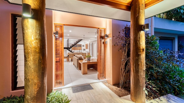 A modern house with a wooden porch, a staircase, and a dining area. - Villa 3 @ Chez Willow (Port Douglas)