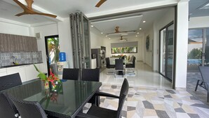 A modern kitchen with white cabinets, a built-in oven, and a large window. - Villa Oasis Tranquille 3 Chambres Avec Piscine (Rawai)