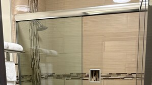 A modern bathroom with a glass-enclosed shower, a toilet, and a sink. - Crystal Palace Inn (Maywood)