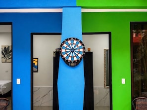 Eine Dartscheibe an einer Wand, gestaltet in Blau- und Grünfarben.