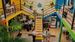 A multi-level hotel lobby with a central staircase, a reception desk, and a mural depicting jungle wildlife. - Carey Lodging  (Colorado)