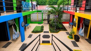 A multi-level atrium with a central staircase, surrounded by colorful walls, a small garden, and outdoor seating. - Carey Lodging  (Colorado)