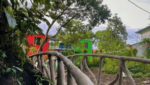 A wooden bridge in a lush garden with a colorful building in the background. - Carey Lodging  (Colorado)