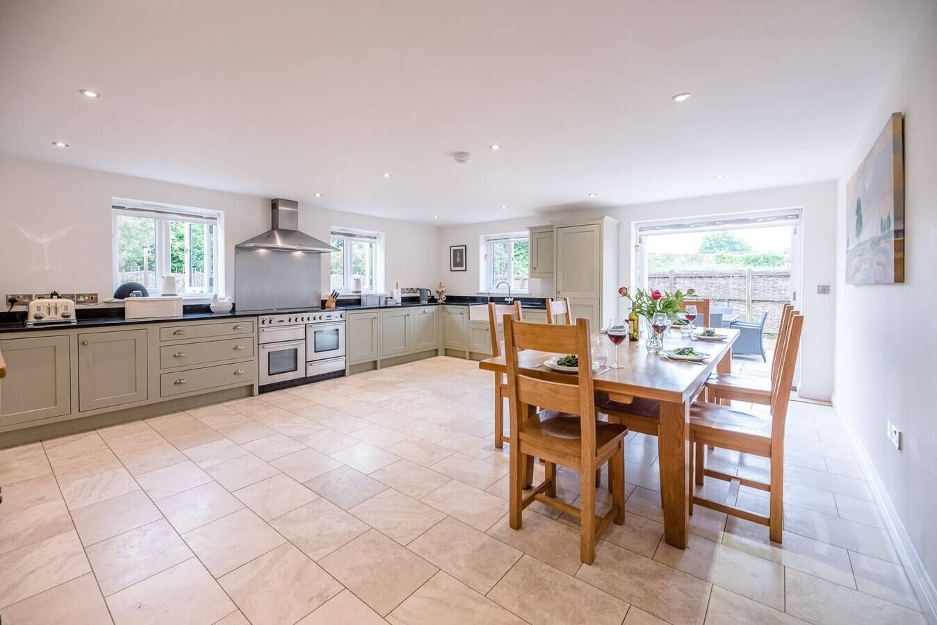 A spacious kitchen with a dining area, large windows, and a view of the outdoors.