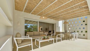 Een moderne woonkamer met een bank, salontafel en een eethoek.