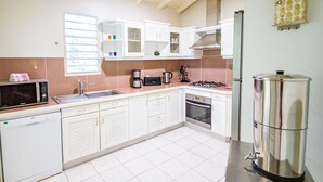 A kitchen with white cabinets, a microwave, a coffee maker, a stove, and a refrigerator. - Villa Familiale Avec Piscine Privée à 5 Minutes de la Plage! (Sainte-Rose)