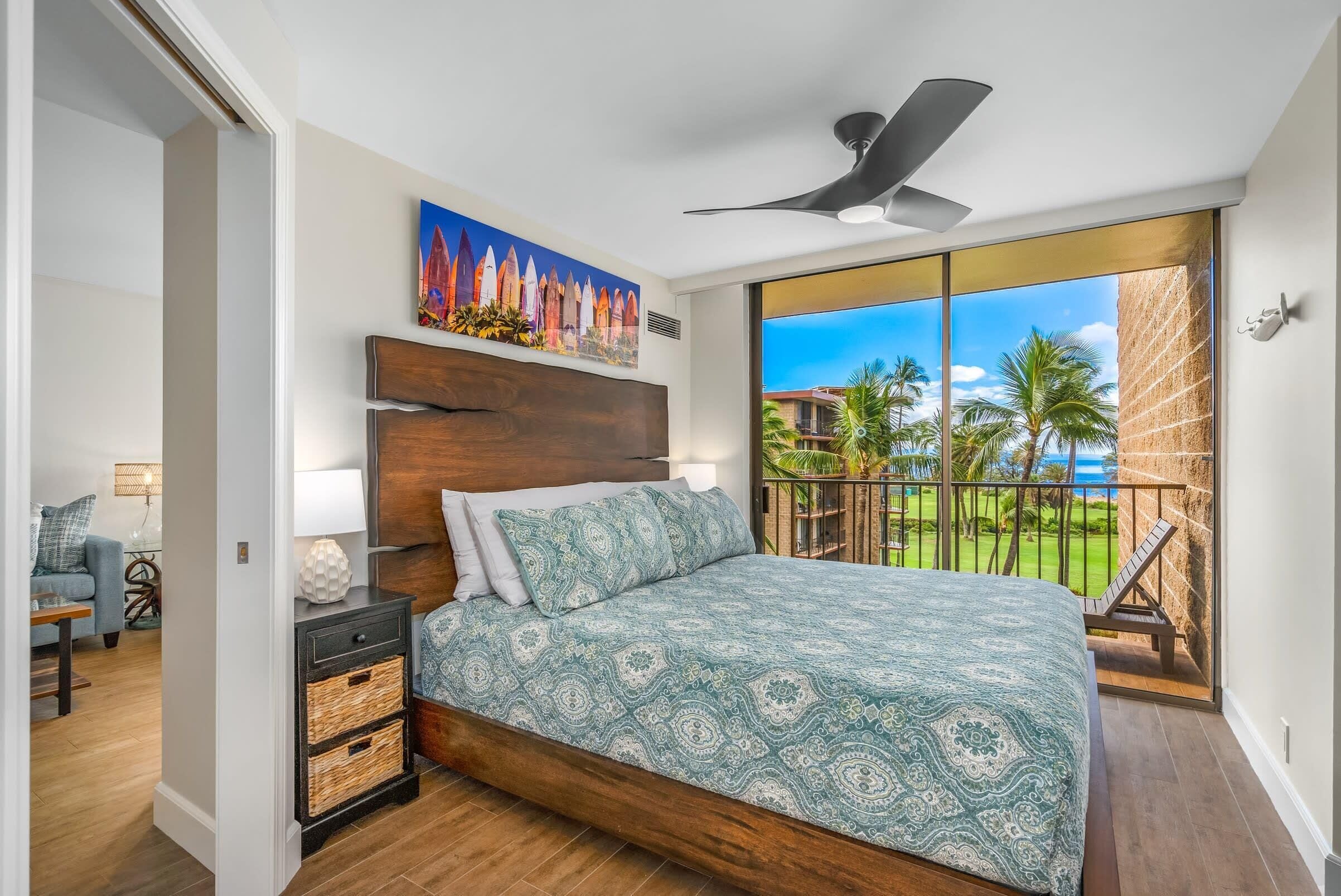 Un dormitorio con una cama grande, un ventilador de techo, vistas al exterior y un cuadro en la pared.