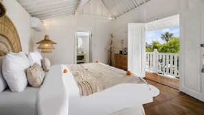 A bedroom with a large bed, a wooden ceiling, and a balcony with a white railing. - Villa Cyma by Alfred in Bali (Seminyak)