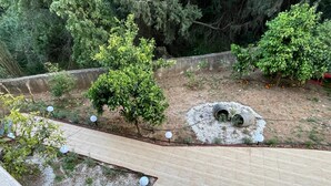 A rooftop garden with a wooden deck, potted plants, and a gravel area with two cylindrical planters. - Zebrano Apartment in Kallithea Rhodes (Rhodes)