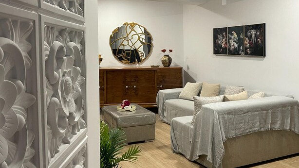 A modern bedroom with two beds, a wooden cabinet, a decorative mirror, and wall art. - Zebrano Apartment in Kallithea Rhodes (Rhodes)