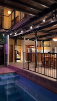 Un hotel de varios niveles con piscina, escalera y zona de comedor.